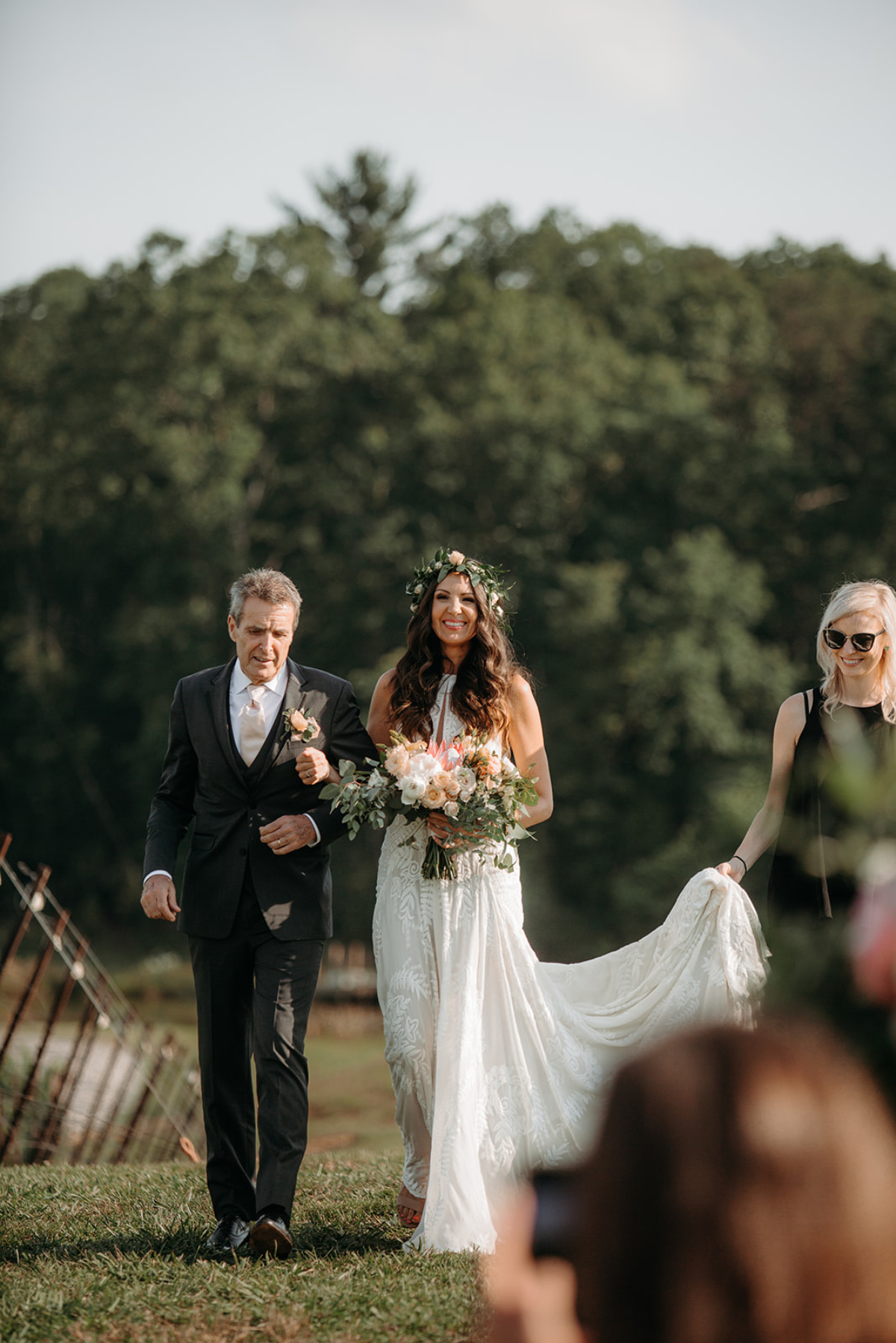 Wedding planner walks behind bride